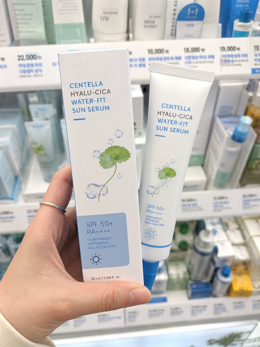AI-assisted editorial visualization of a generic lightweight centella sun-serum tube in a Korean beauty store · package reference