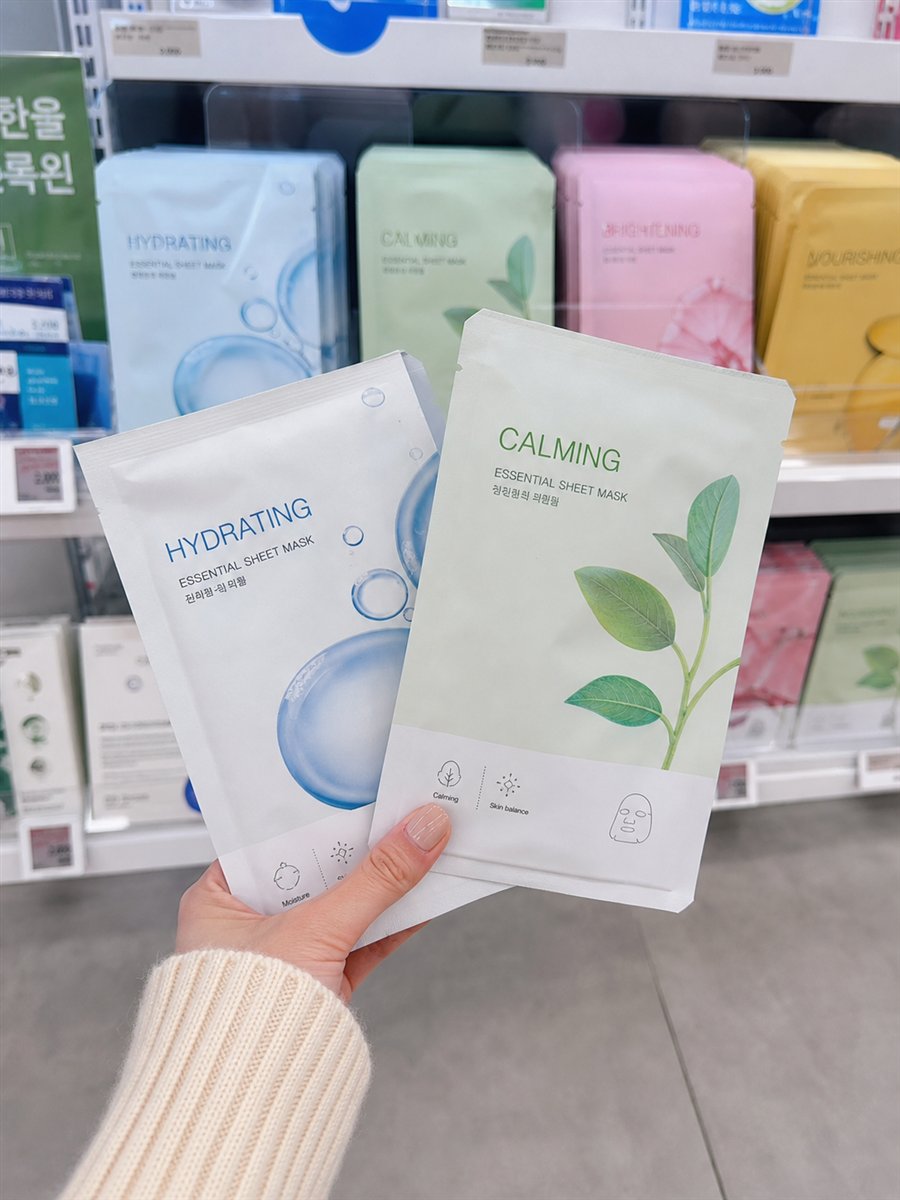 AI-assisted editorial visualization of a traveler comparing generic Korean sheet masks in a Seoul beauty store · package reference